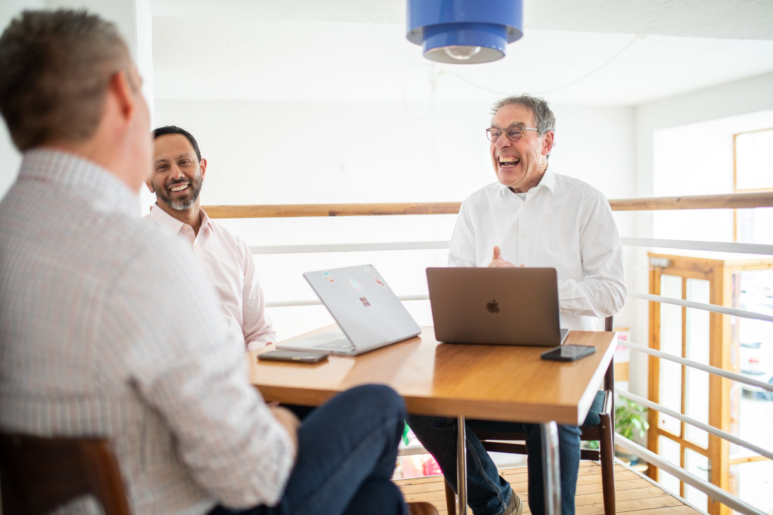 Employees sitting at a table, laughing