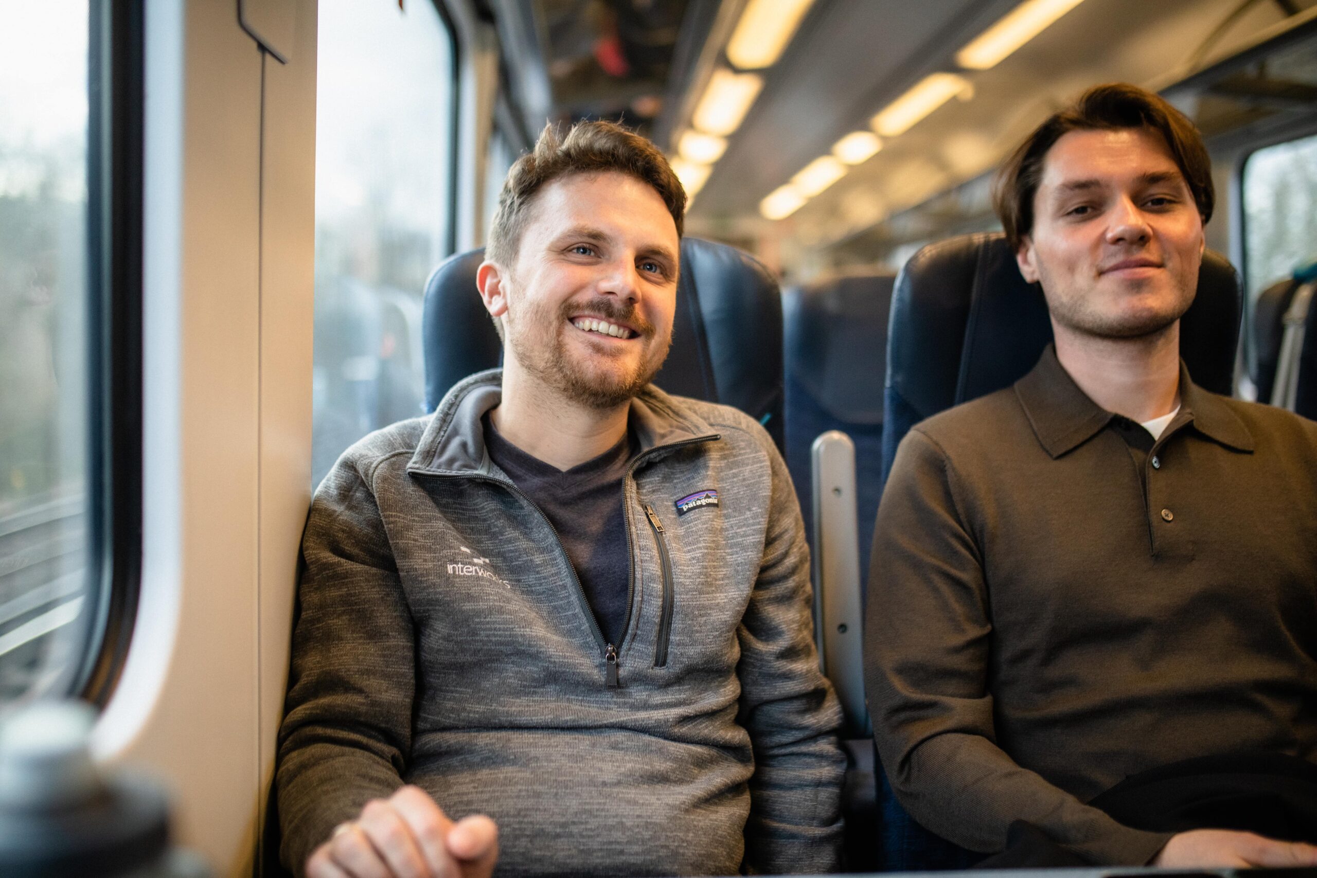 Two individuals sitting together on a train